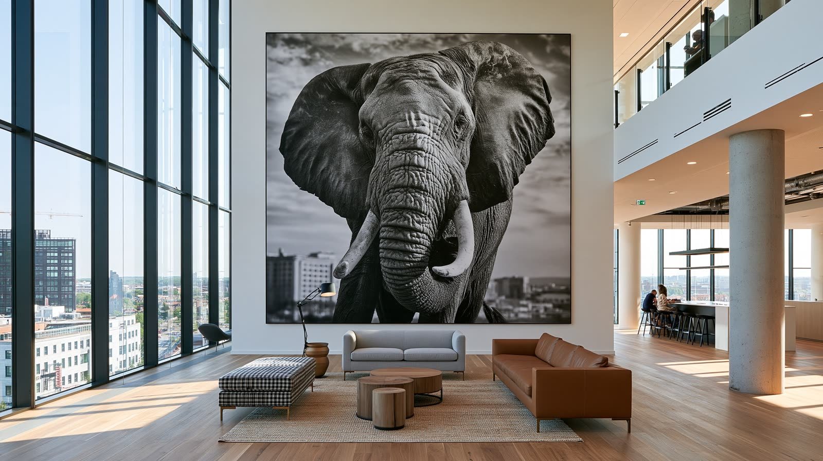 Un éléphant photographié de face, tirage monumental dans un hall vitré ouvert sur la ville.